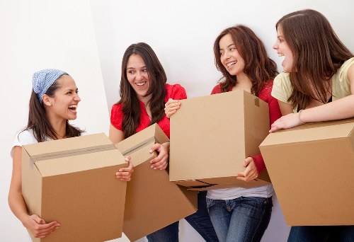 Professional movers carrying furniture on a Clapham residential street